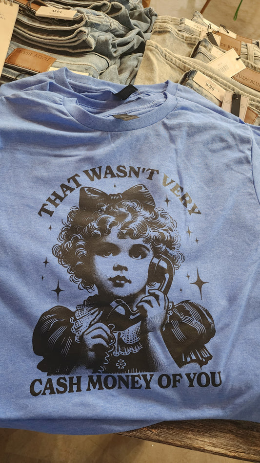 A light blue graphic t-shirt featuring a vintage-style illustration of a young girl on a telephone with the text 'THAT WASN'T VERY CASH MONEY OF YOU' printed in black and gray.